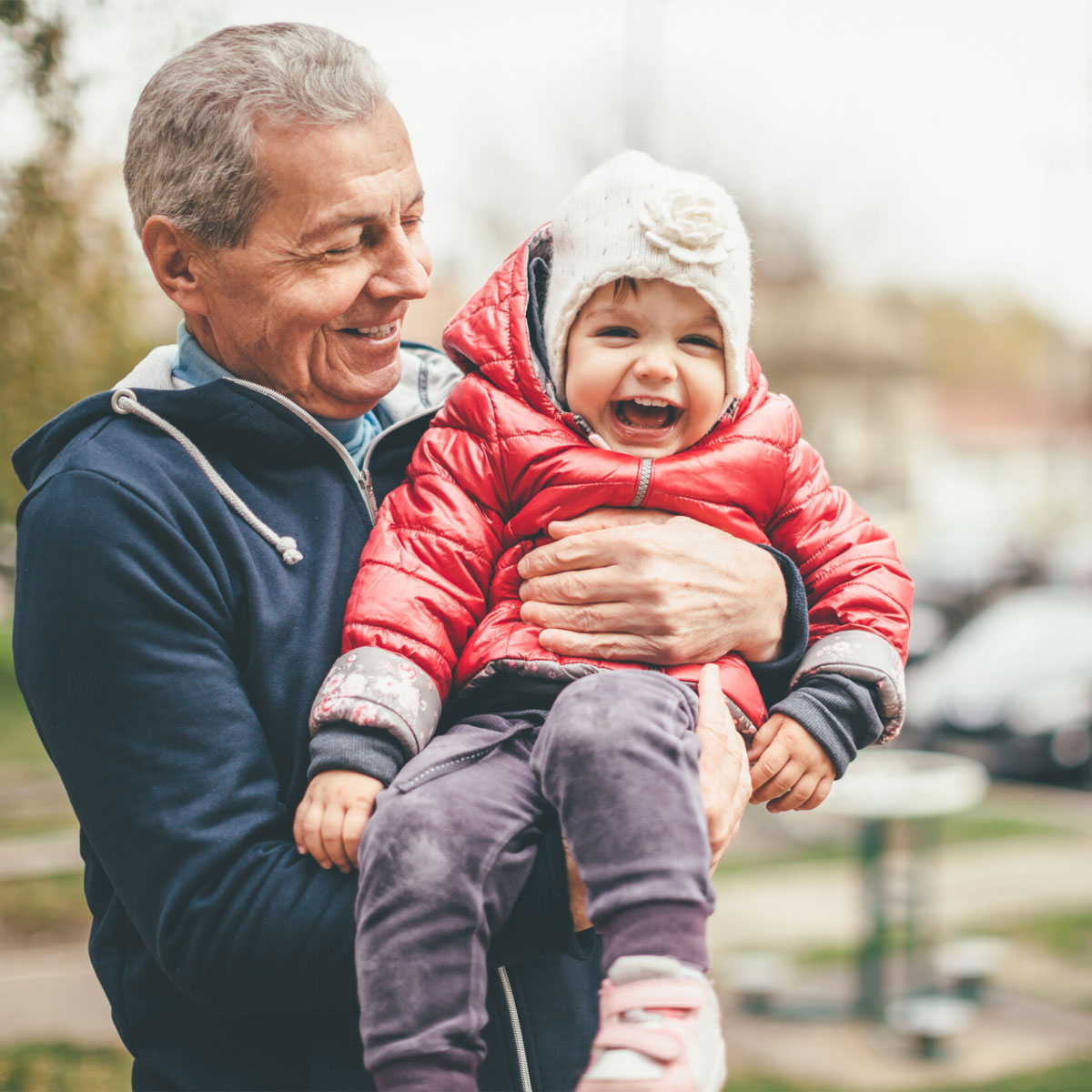 A grandfather holding their grandchild.