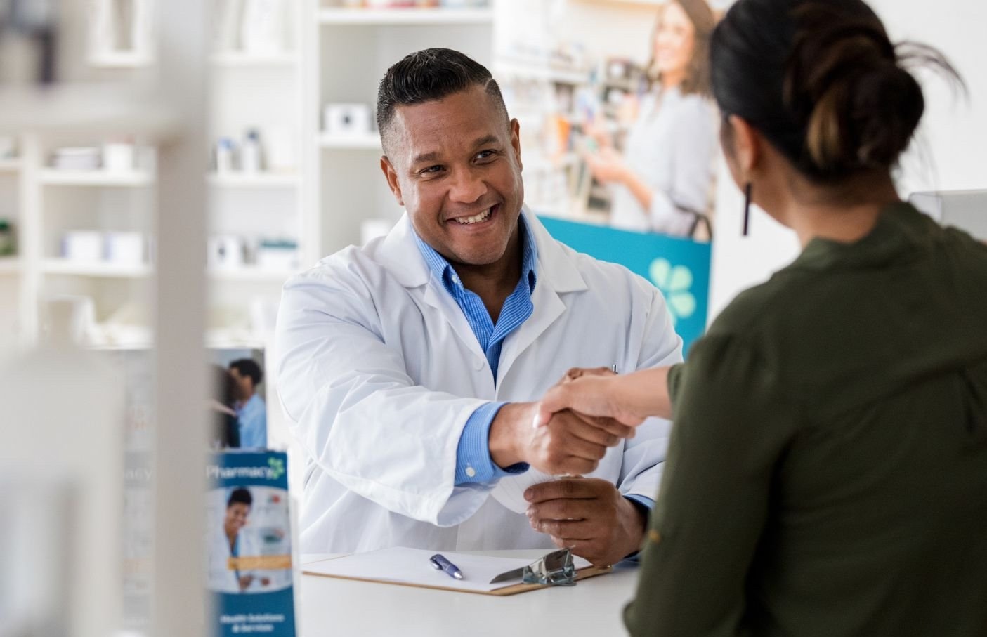 A Pharmacist shaking a buyers hand.